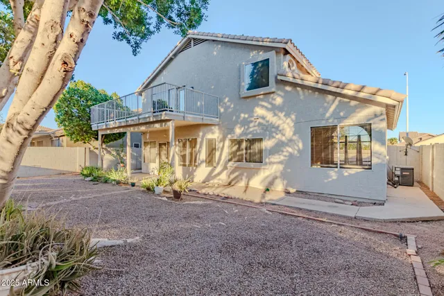 a view of a house with backyard and a tree