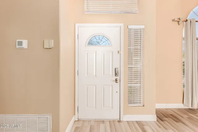 a view of a bedroom with wooden floor and door