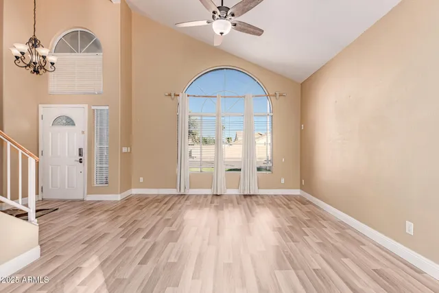 a view of an empty room with wooden floor and a large window