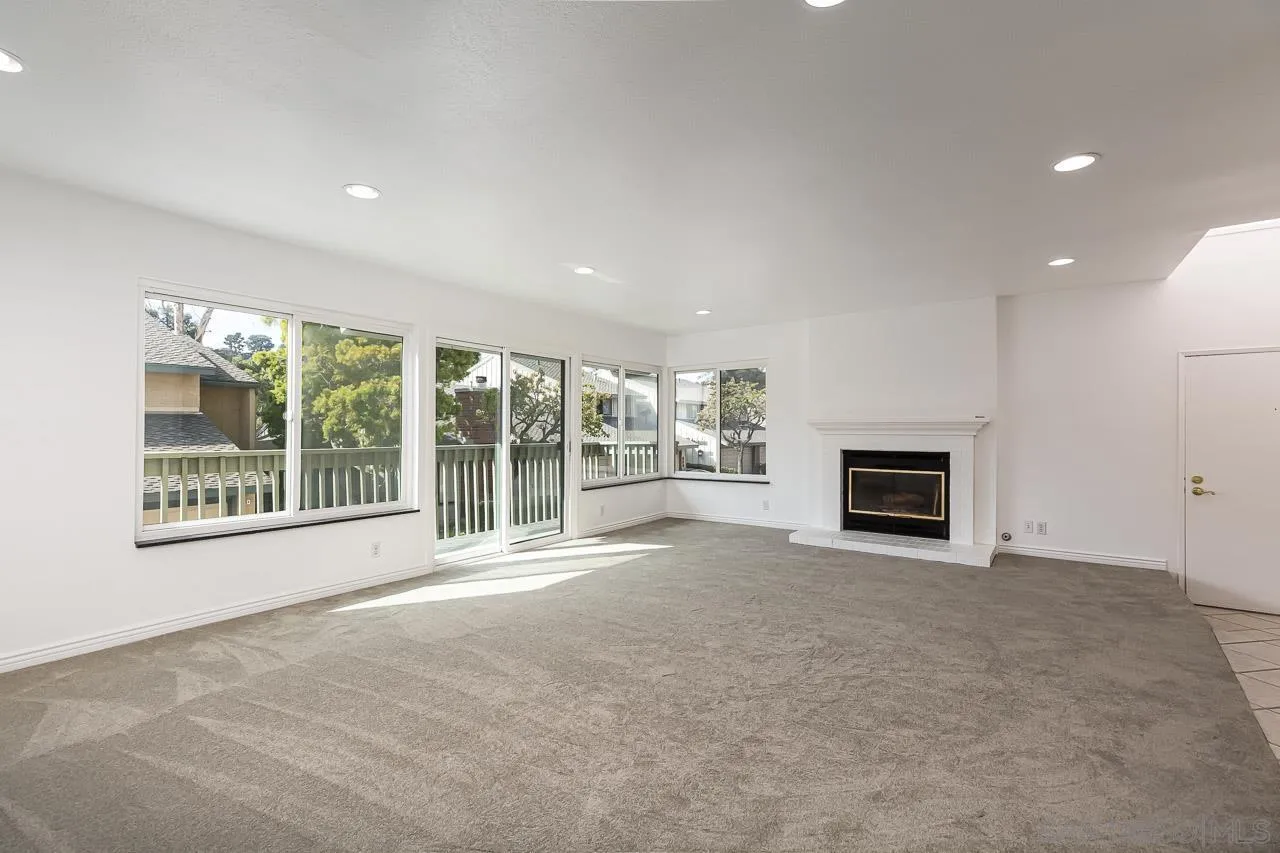 8065 Caminito Gianna La Jolla, CA 92037 - Photo 3 of 27 a view of an empty room with a fireplace and a window