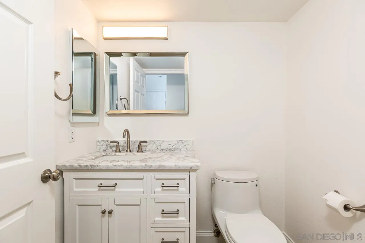 8065 Caminito Gianna La Jolla, CA 92037 - Photo 7 of 27 a bathroom with a granite countertop toilet sink and mirror