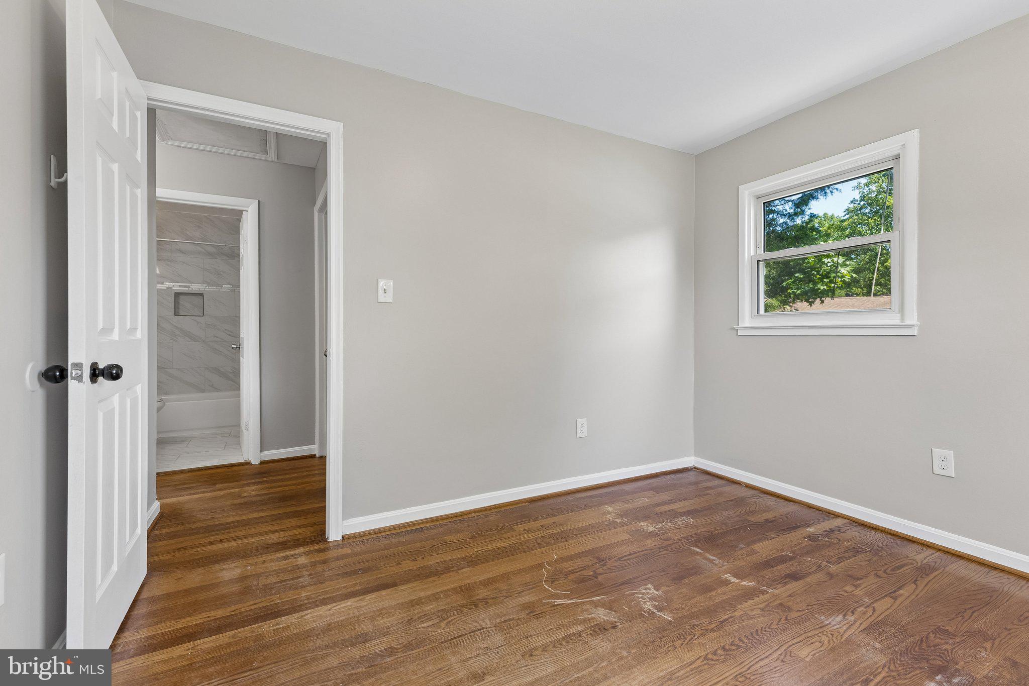 14197 Fullerton Road Woodbridge, VA 22193 - Photo 18 of 23 a view of an empty room with wooden floor and a window