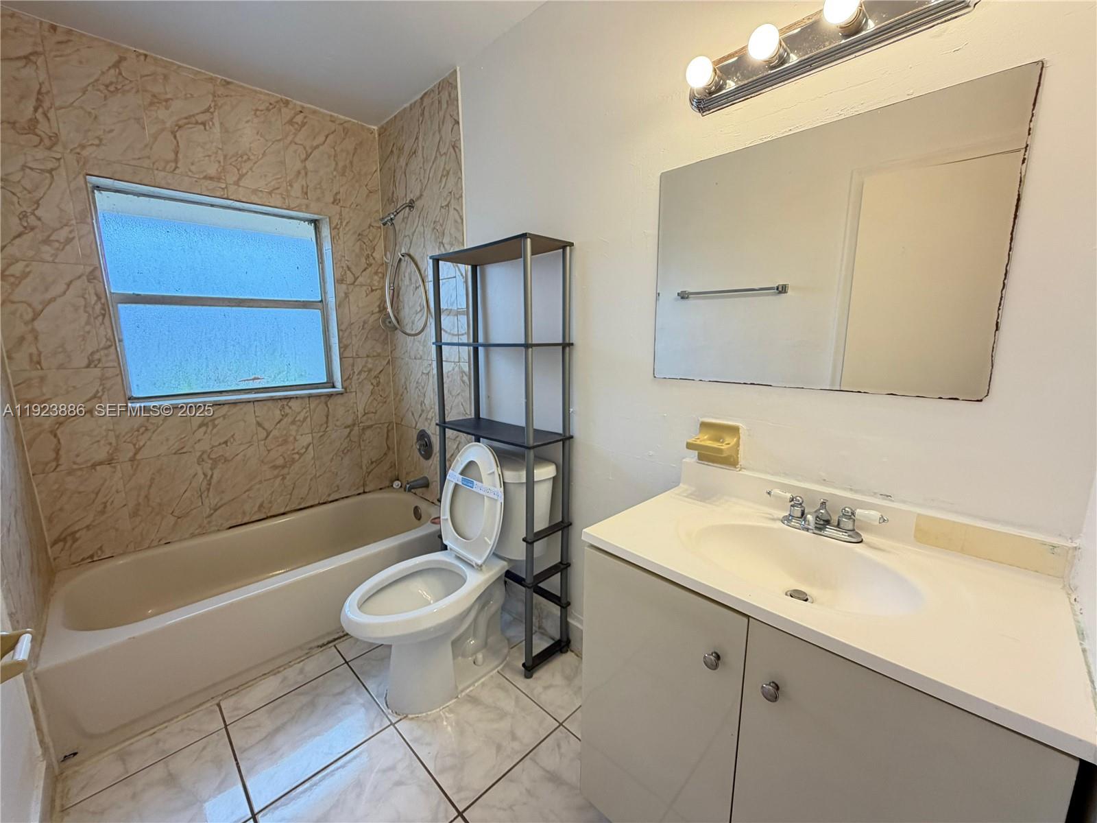 5327 Northwest 27th Street, Unit D4 Lauderhill, FL 33313 - Photo 11 of 14 a bathroom with a sink a toilet and shower