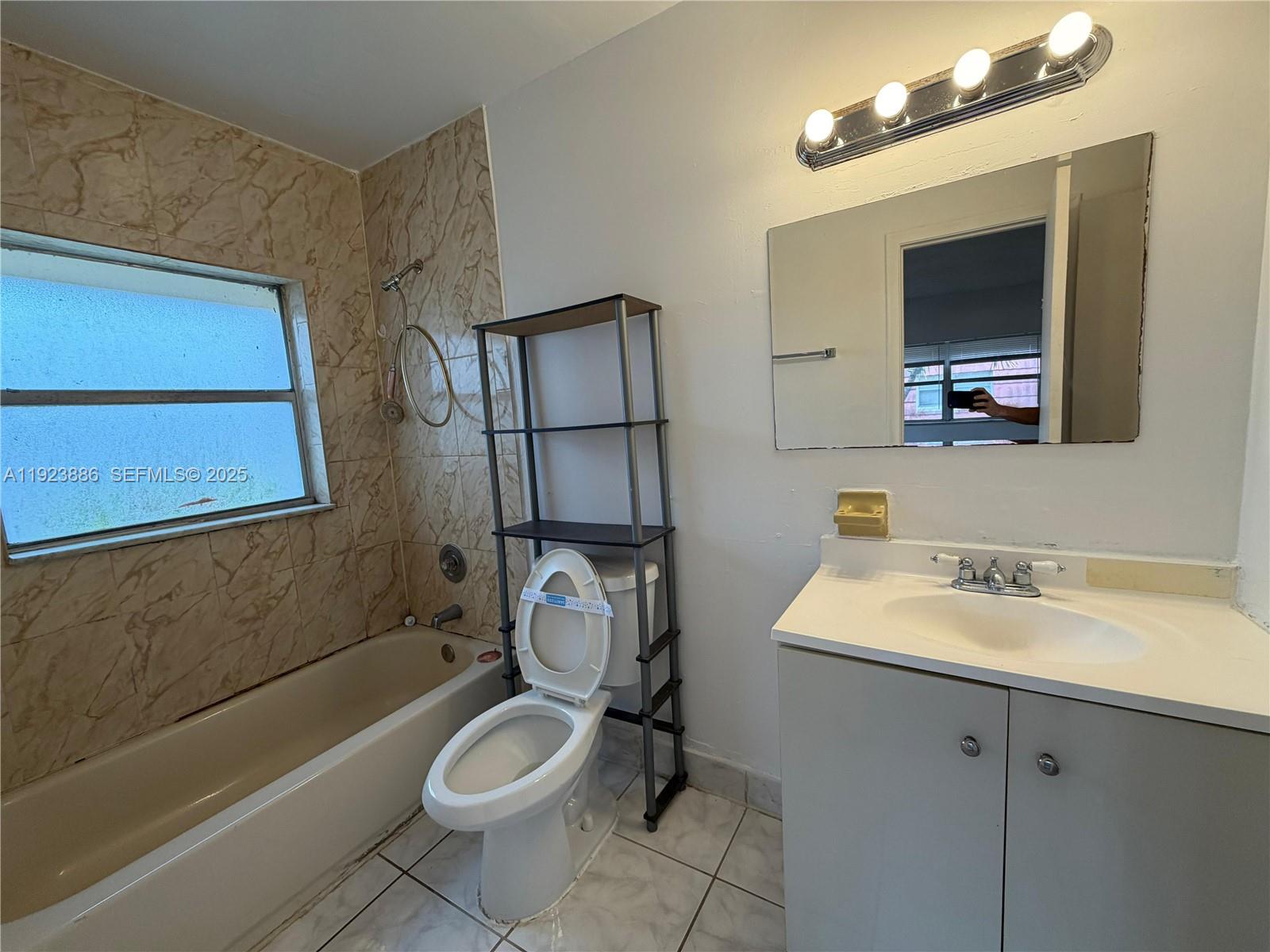 5327 Northwest 27th Street, Unit D4 Lauderhill, FL 33313 - Photo 12 of 14 a bathroom with a granite countertop toilet sink and mirror