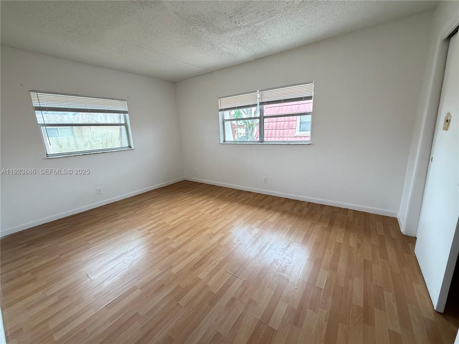 5327 Northwest 27th Street, Unit D4 Lauderhill, FL 33313 - Photo 9 of 14 a view of an empty room with wooden floor and a window