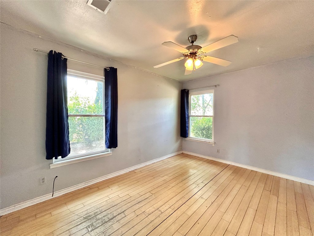 2309 Devonshire Drive, Unit A Austin, TX 78723 - Photo 17 of 39 Empty room with light wood finished floors, a textured ceiling, and a ceiling fan