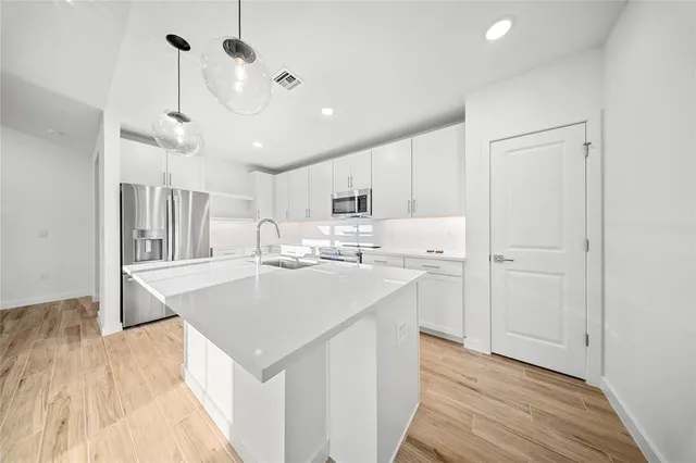 a kitchen with kitchen island a sink and wooden floor
