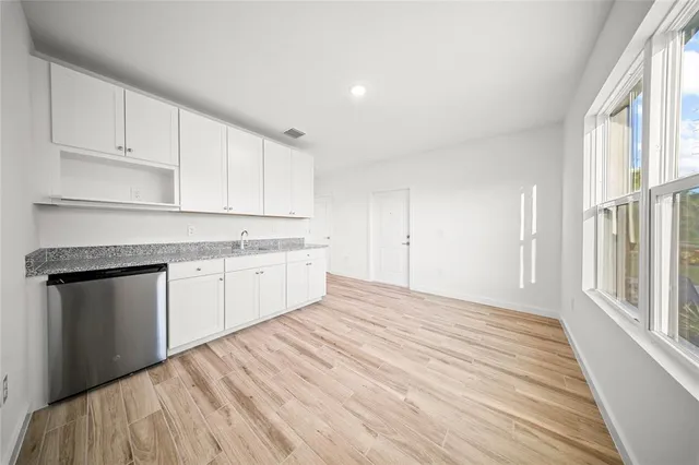 a kitchen with granite countertop white cabinets and white appliances