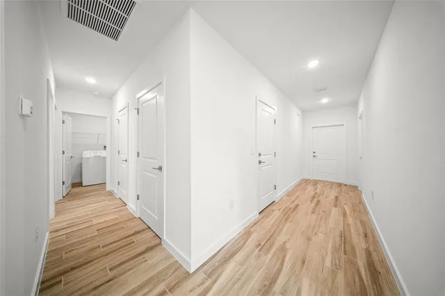 a view of a hallway with wooden floor