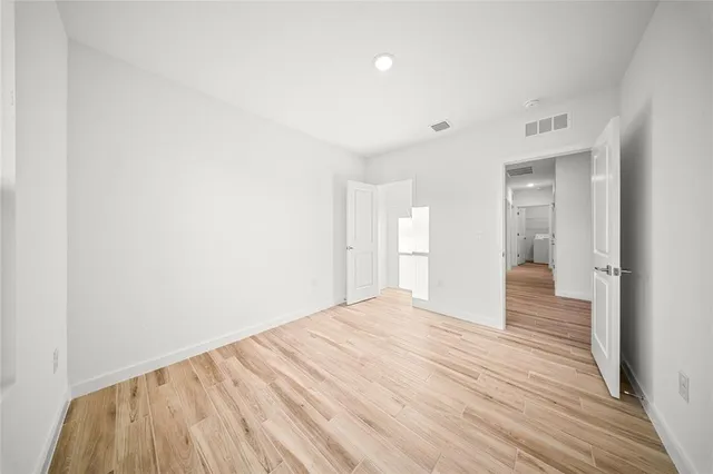 a view of a room with wooden floor and a ceiling fan