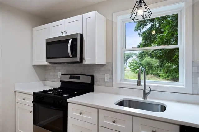 a kitchen with a sink stove and microwave