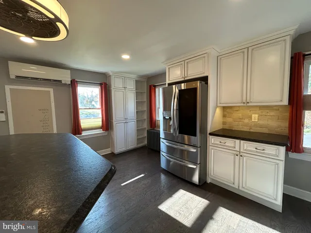 a kitchen with stainless steel appliances kitchen island granite countertop a refrigerator and a stove