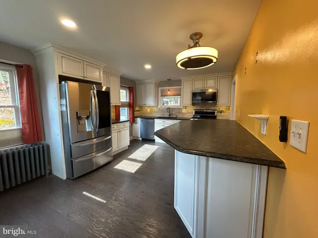a kitchen with stainless steel appliances granite countertop a sink refrigerator and cabinets