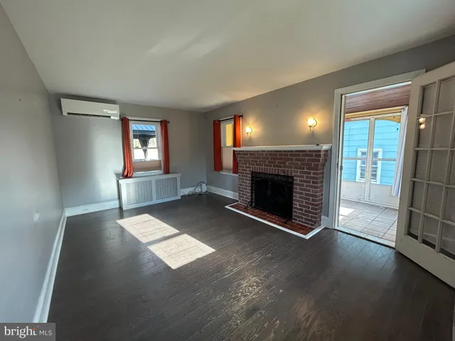 a view of a livingroom with a fireplace and window