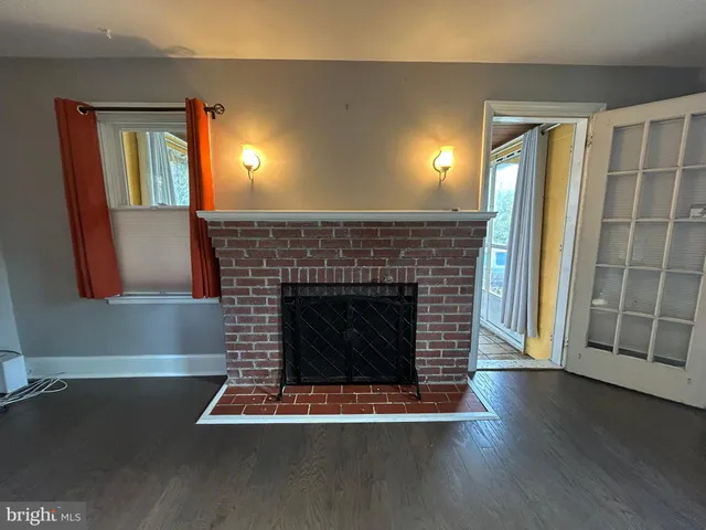 a living room with a fireplace and wooden floor