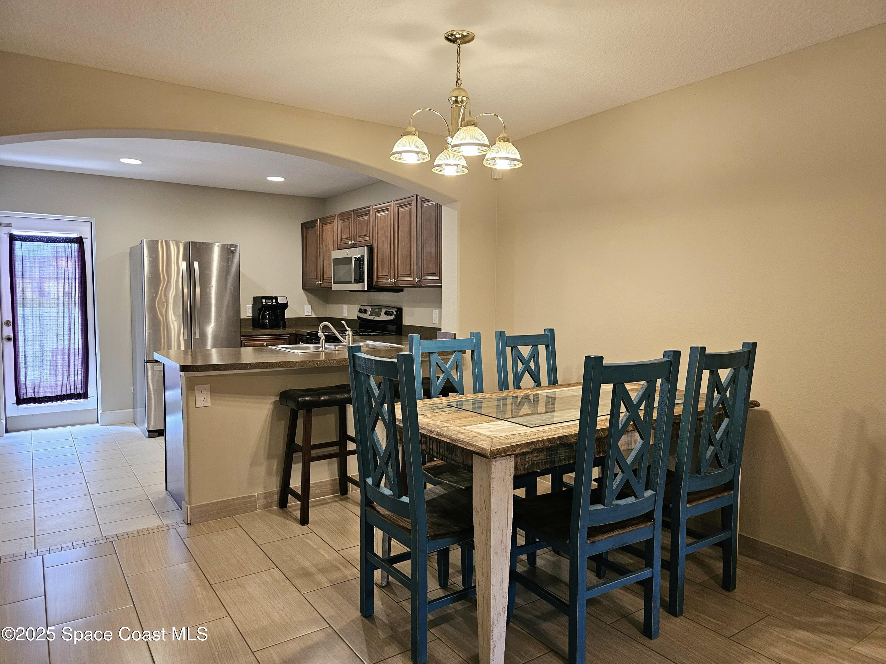 4570 Radiant Way, Unit 104 Melbourne, FL 32901 - Photo 11 of 41 a view of a dining room with furniture and a chandelier