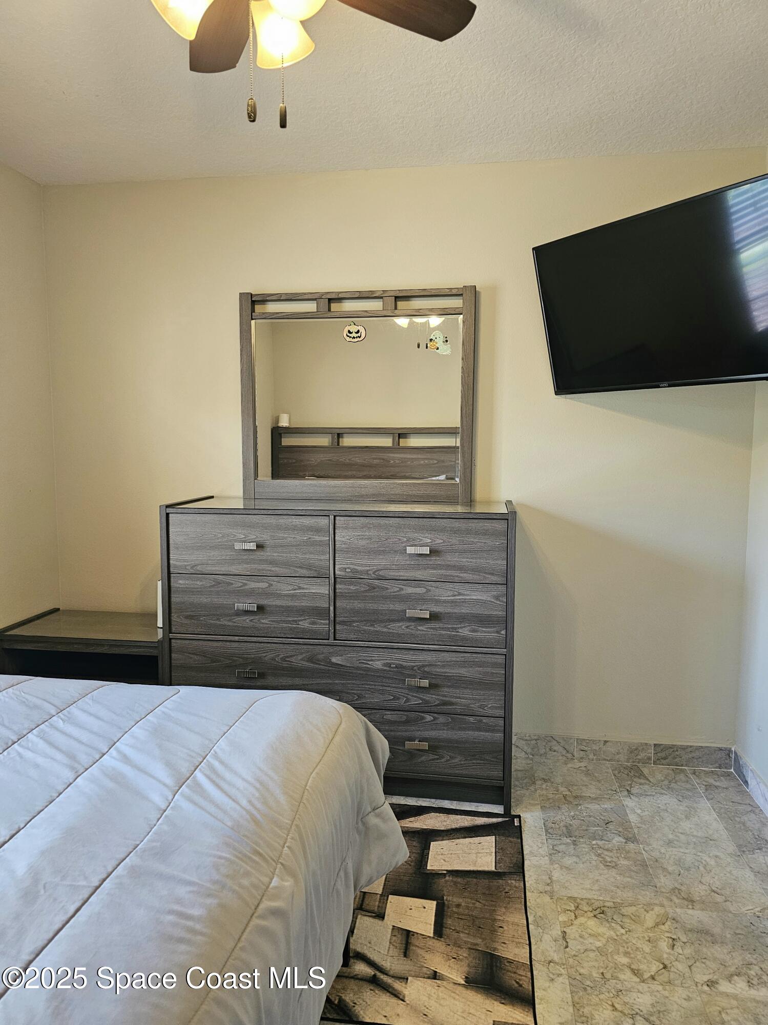 4570 Radiant Way, Unit 104 Melbourne, FL 32901 - Photo 15 of 41 a bedroom with a bed and a flat screen tv