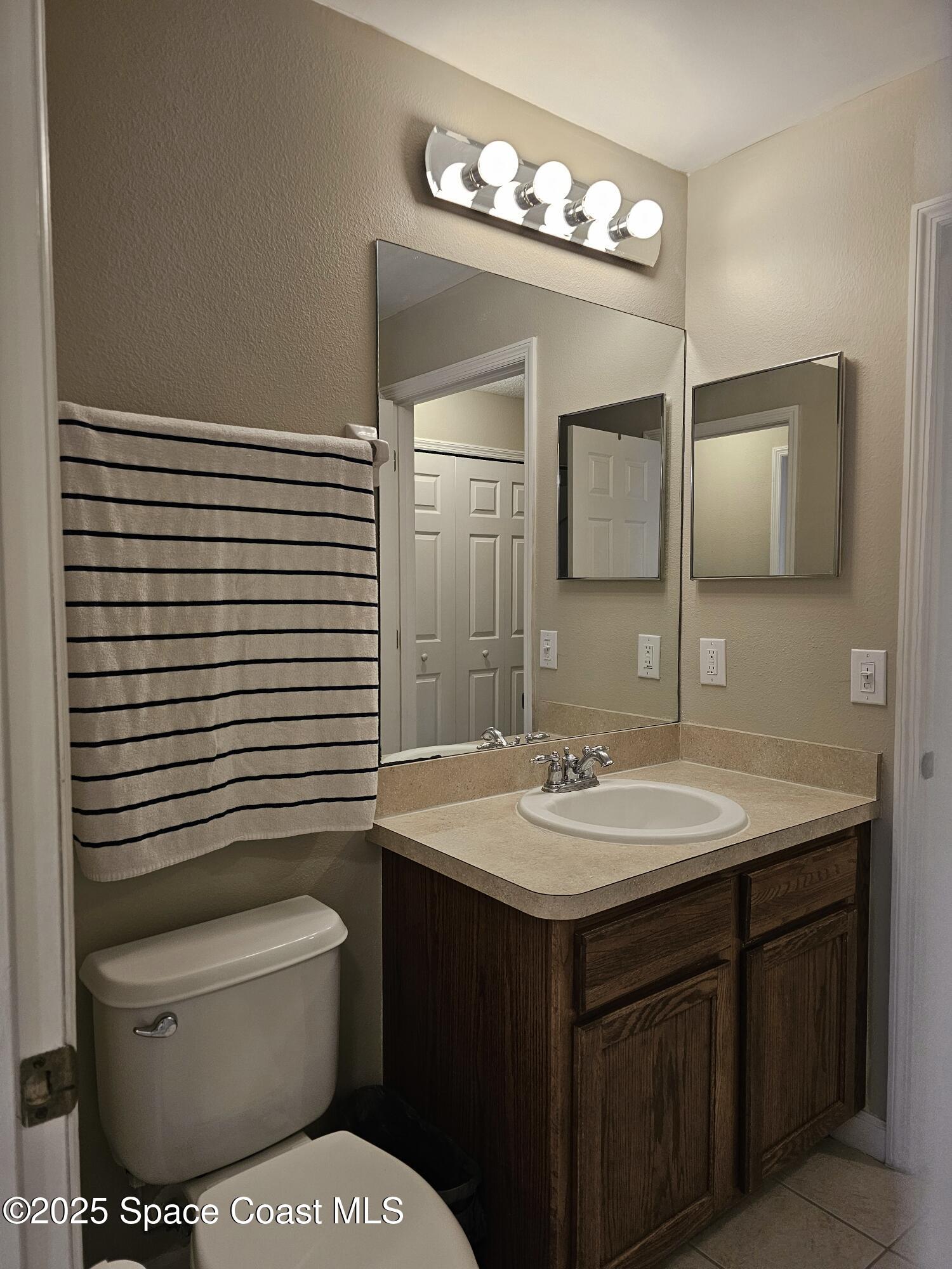 4570 Radiant Way, Unit 104 Melbourne, FL 32901 - Photo 16 of 41 a bathroom with a toilet sink and mirror