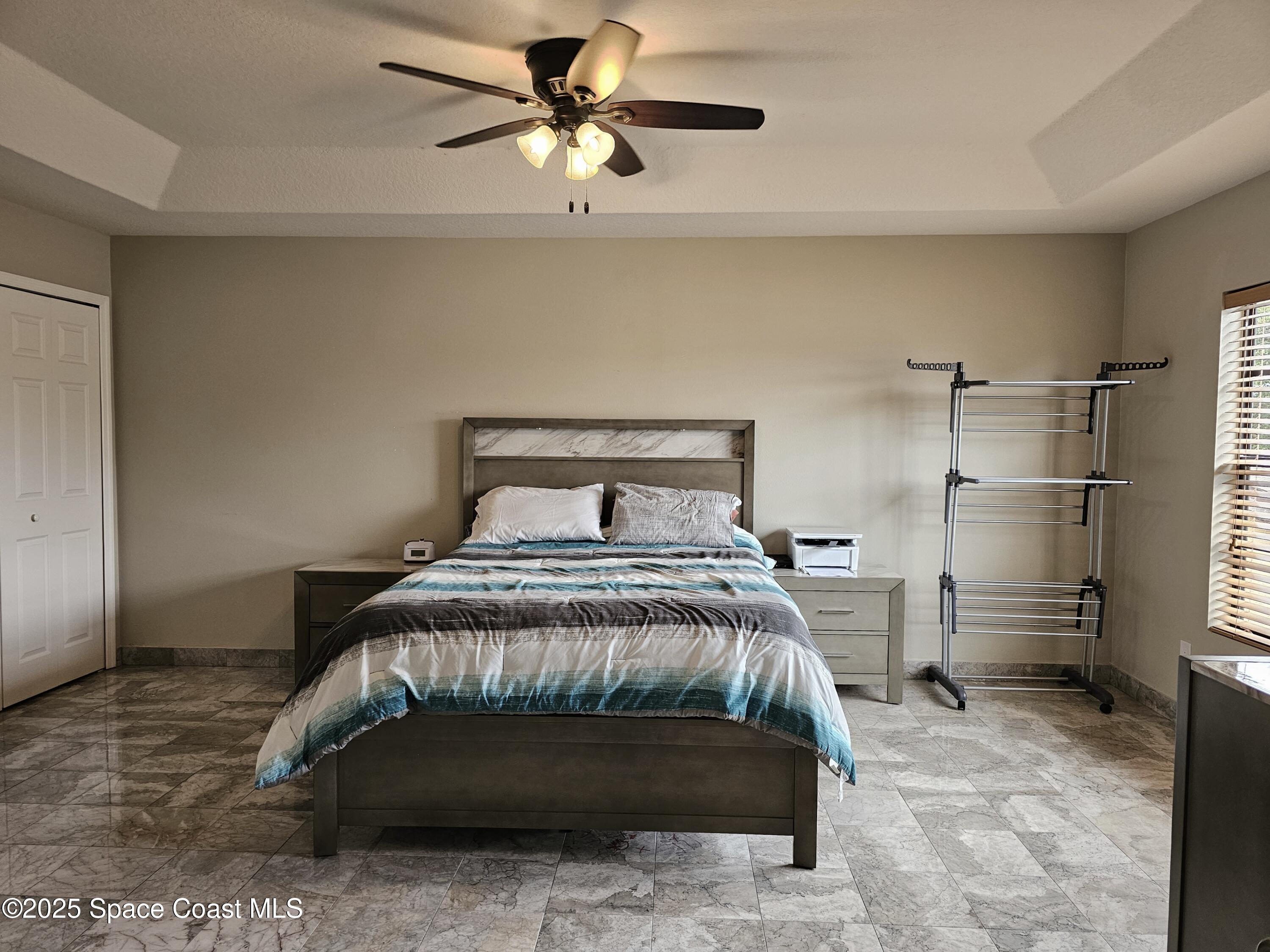 4570 Radiant Way, Unit 104 Melbourne, FL 32901 - Photo 20 of 41 a bedroom with a bed and a chandelier