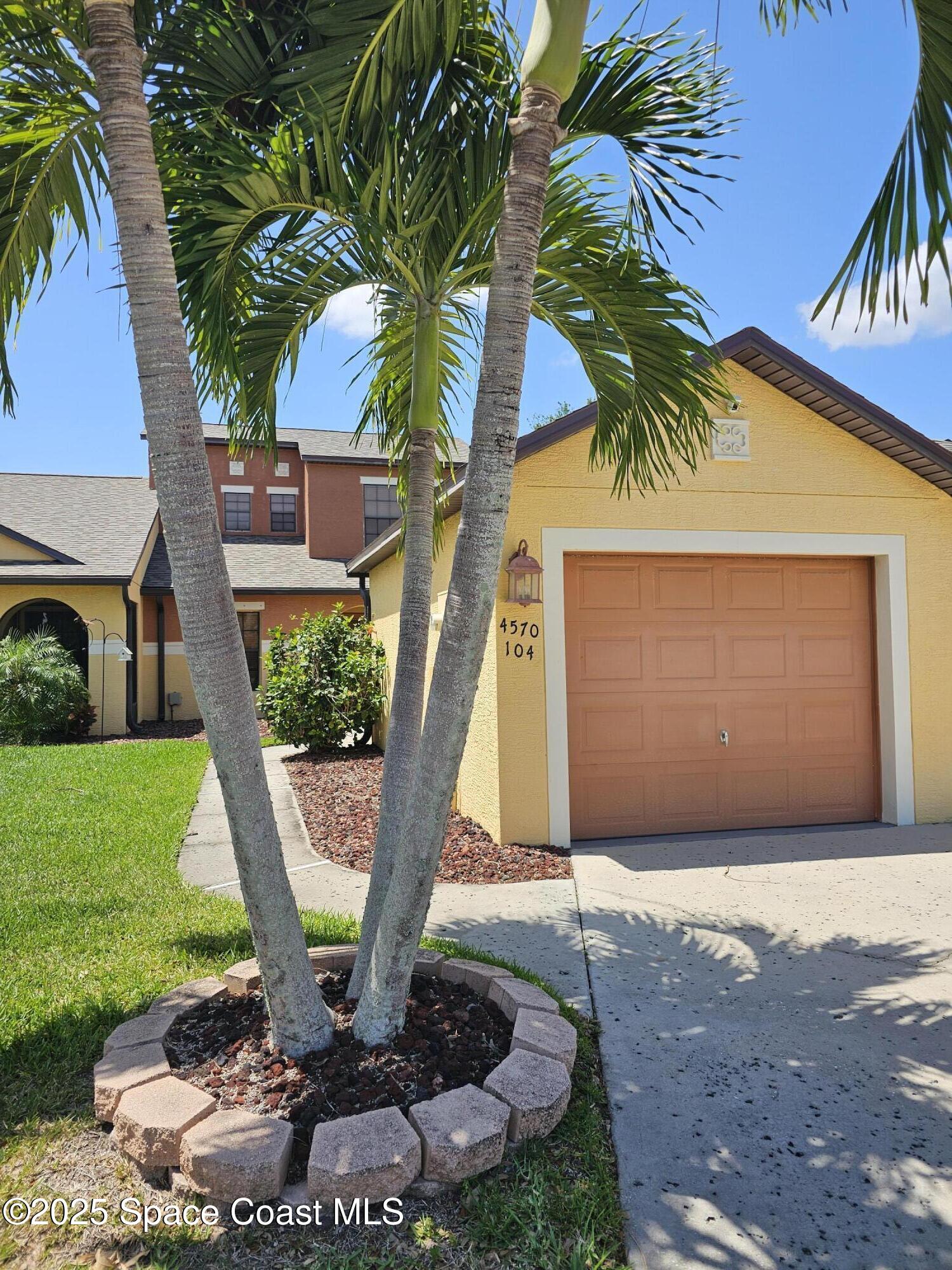 4570 Radiant Way, Unit 104 Melbourne, FL 32901 - Photo 2 of 41 a front view of a house with garden
