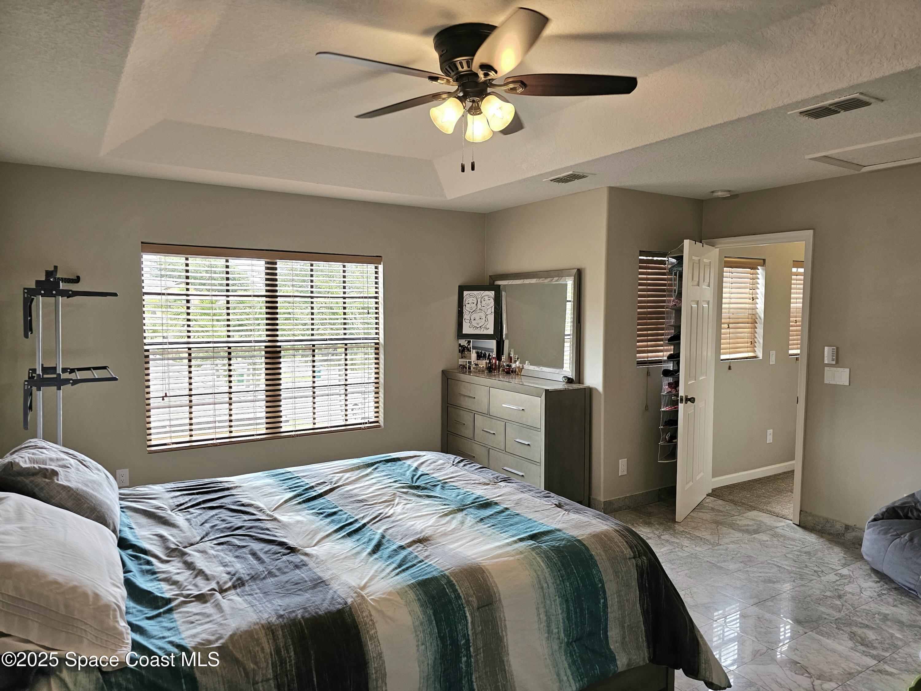 4570 Radiant Way, Unit 104 Melbourne, FL 32901 - Photo 22 of 41 a bedroom with a bed and a chandelier