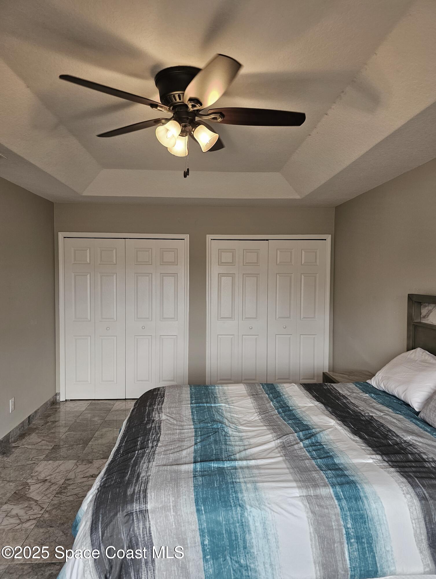 4570 Radiant Way, Unit 104 Melbourne, FL 32901 - Photo 23 of 41 a bedroom with a large bed and a chandelier