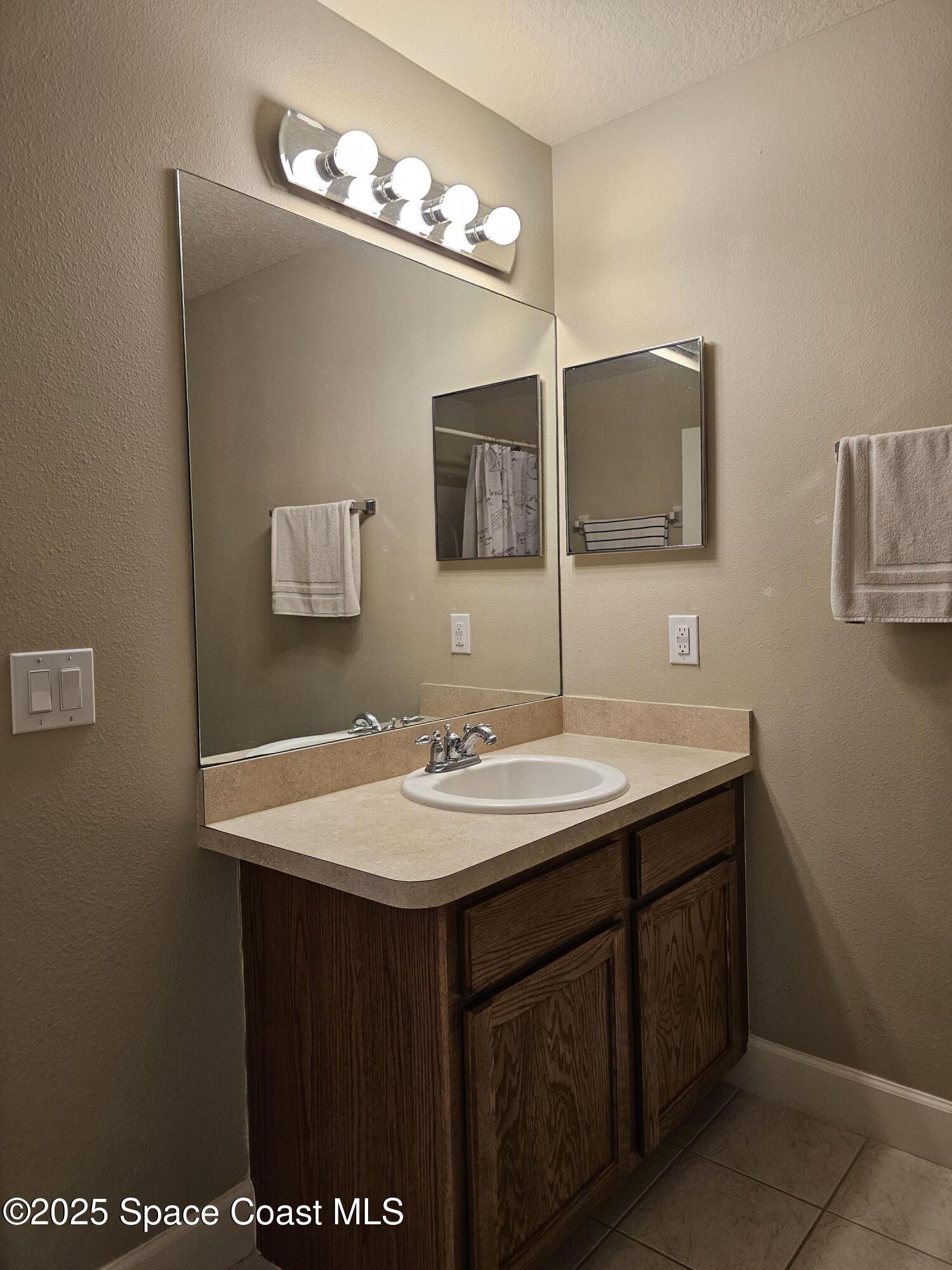 4570 Radiant Way, Unit 104 Melbourne, FL 32901 - Photo 25 of 41 a bathroom with a sink and a mirror