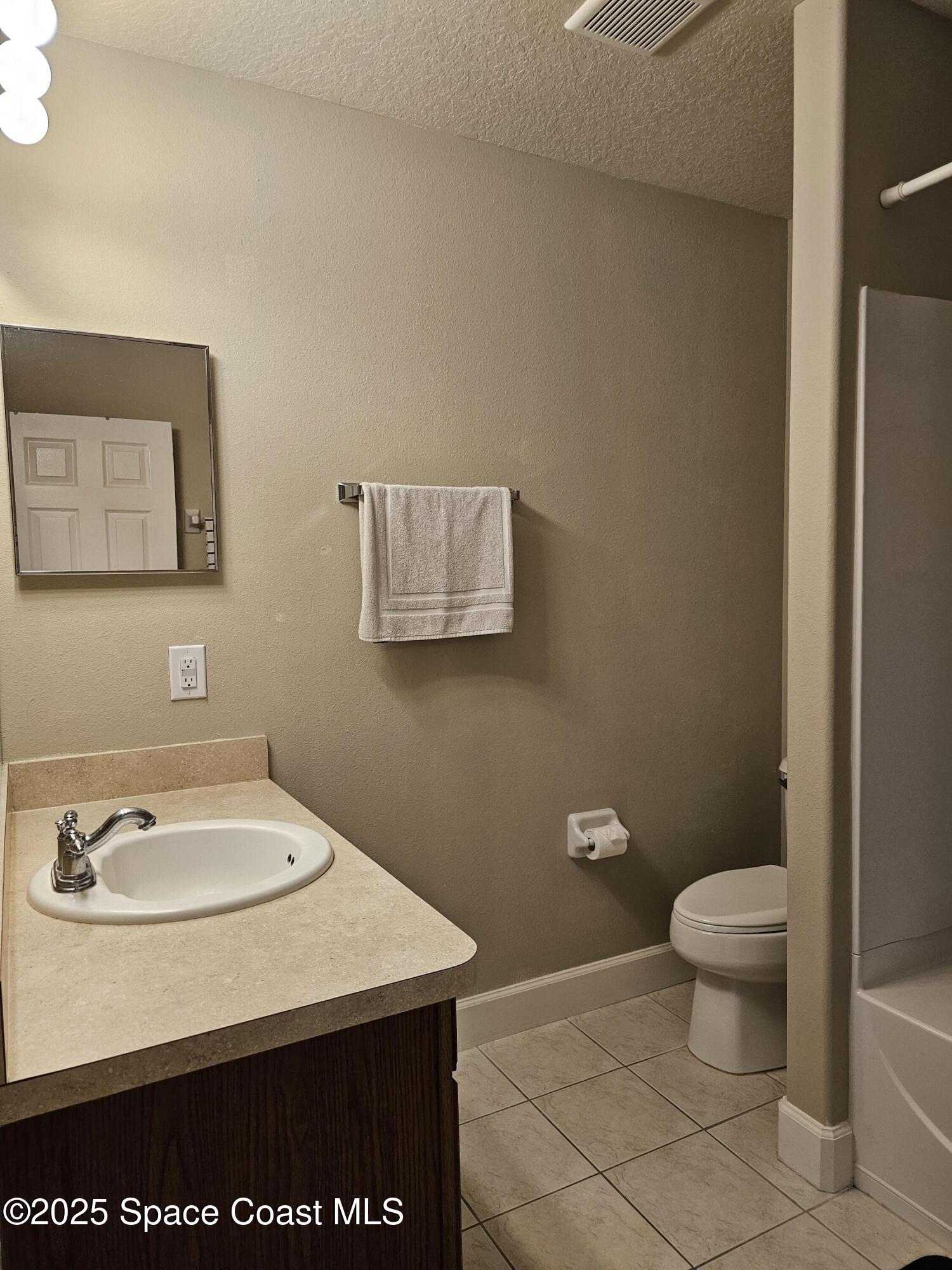 4570 Radiant Way, Unit 104 Melbourne, FL 32901 - Photo 26 of 41 a bathroom with a sink a toilet and a mirror