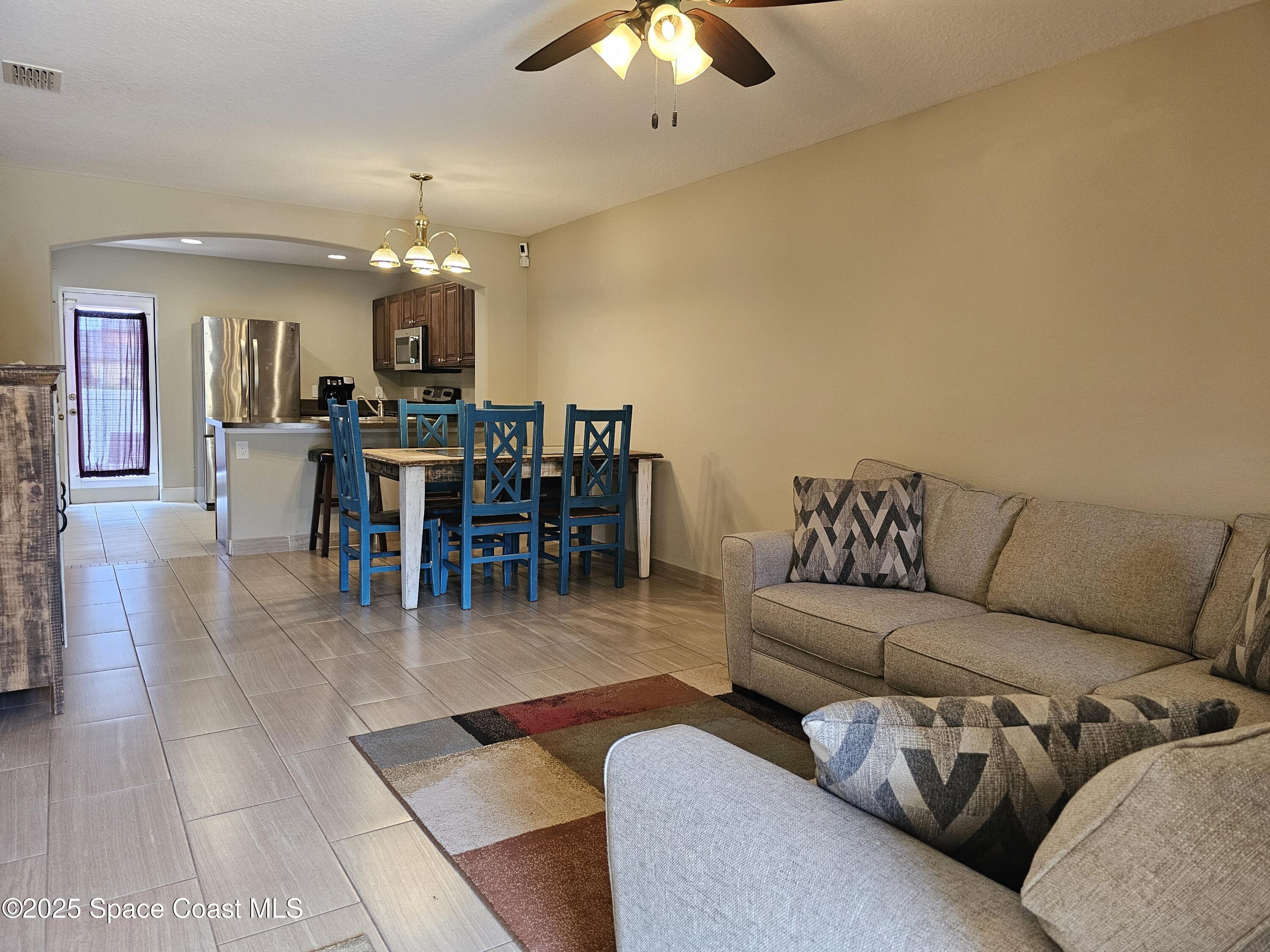 4570 Radiant Way, Unit 104 Melbourne, FL 32901 - Photo 3 of 41 a living room with furniture a dining table and a chandelier