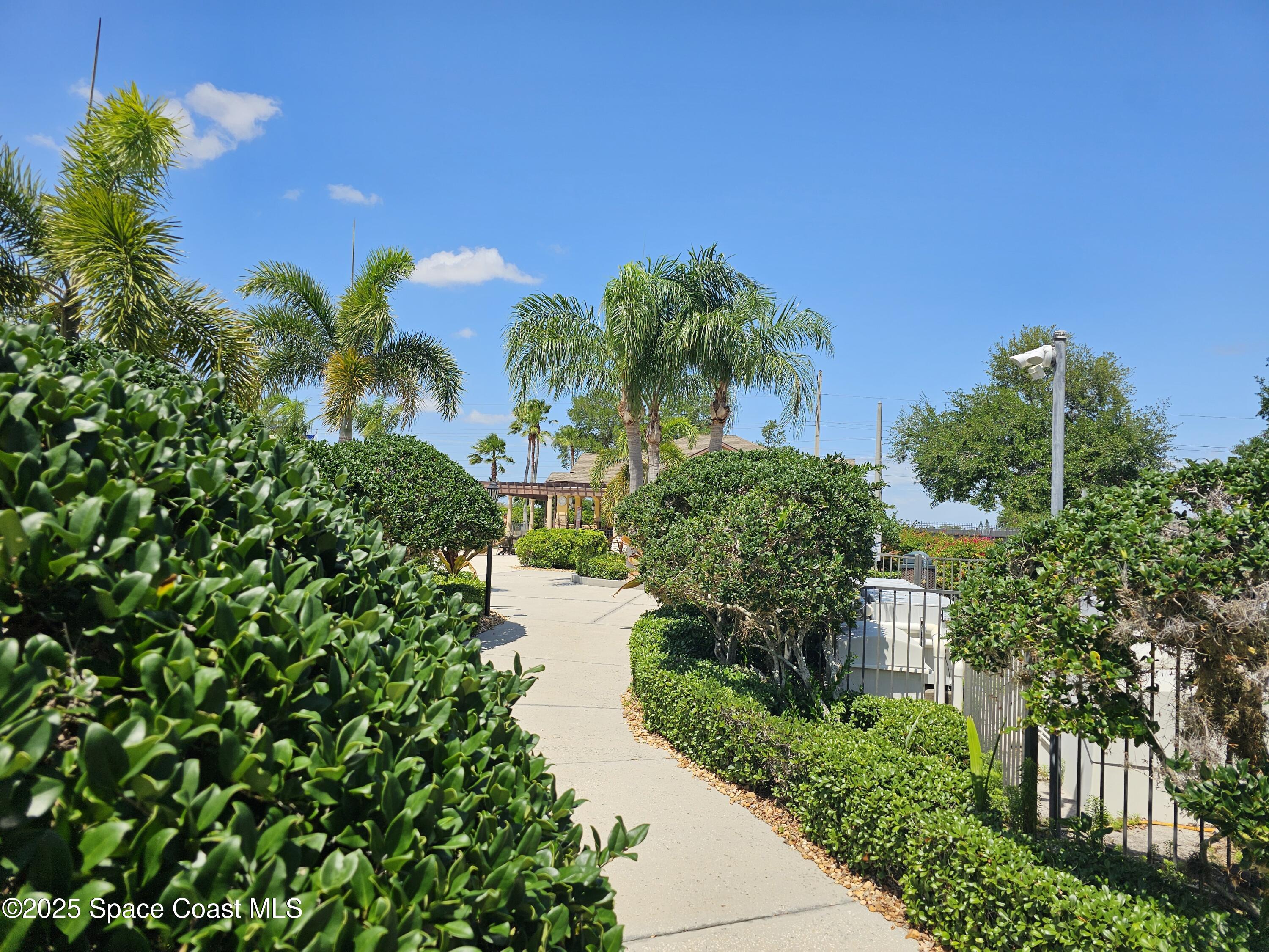 4570 Radiant Way, Unit 104 Melbourne, FL 32901 - Photo 37 of 41 a view of a garden with a building in the background