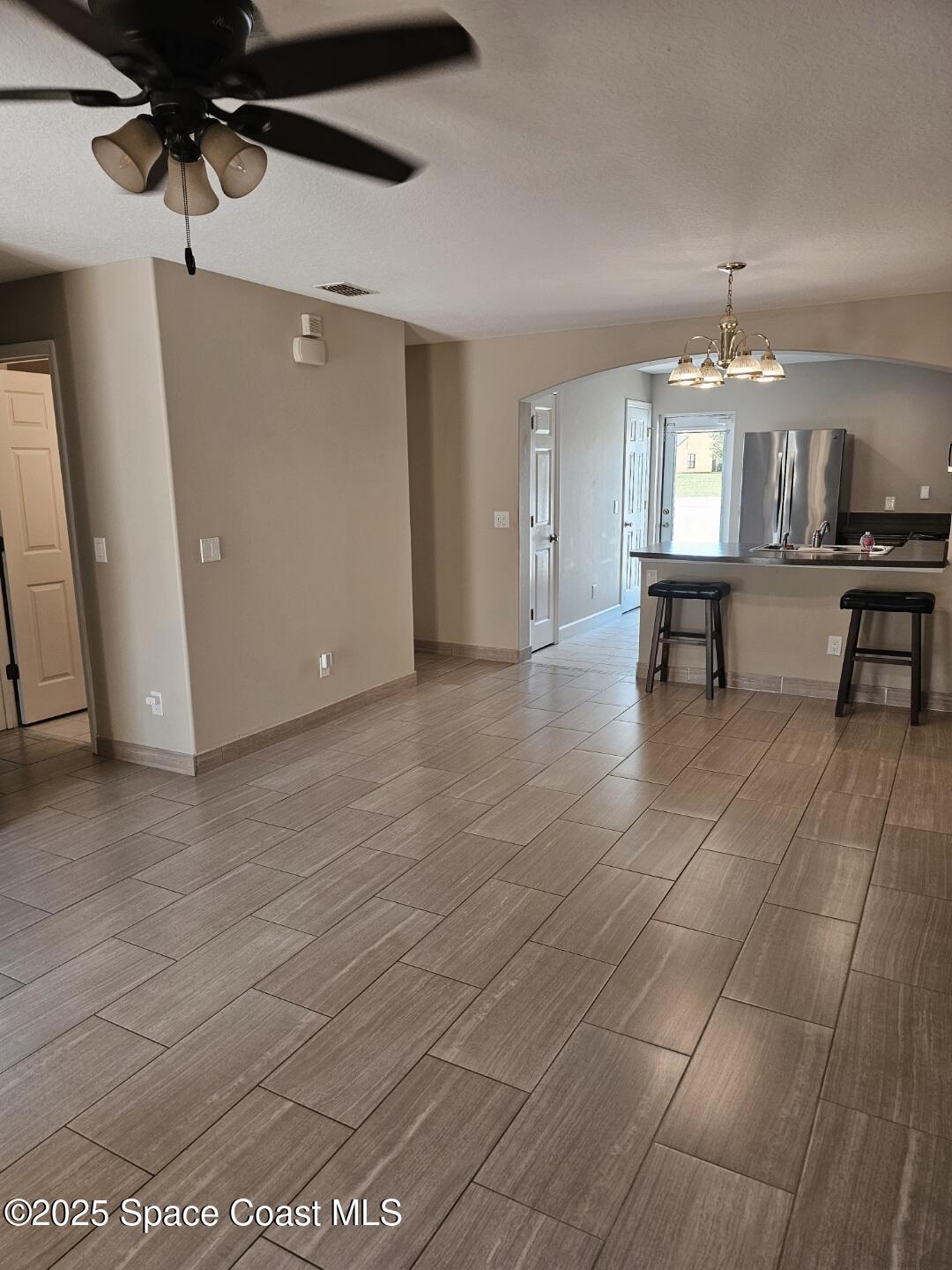 4570 Radiant Way, Unit 104 Melbourne, FL 32901 - Photo 4 of 41 a view of a livingroom with wooden floor and a ceiling fan