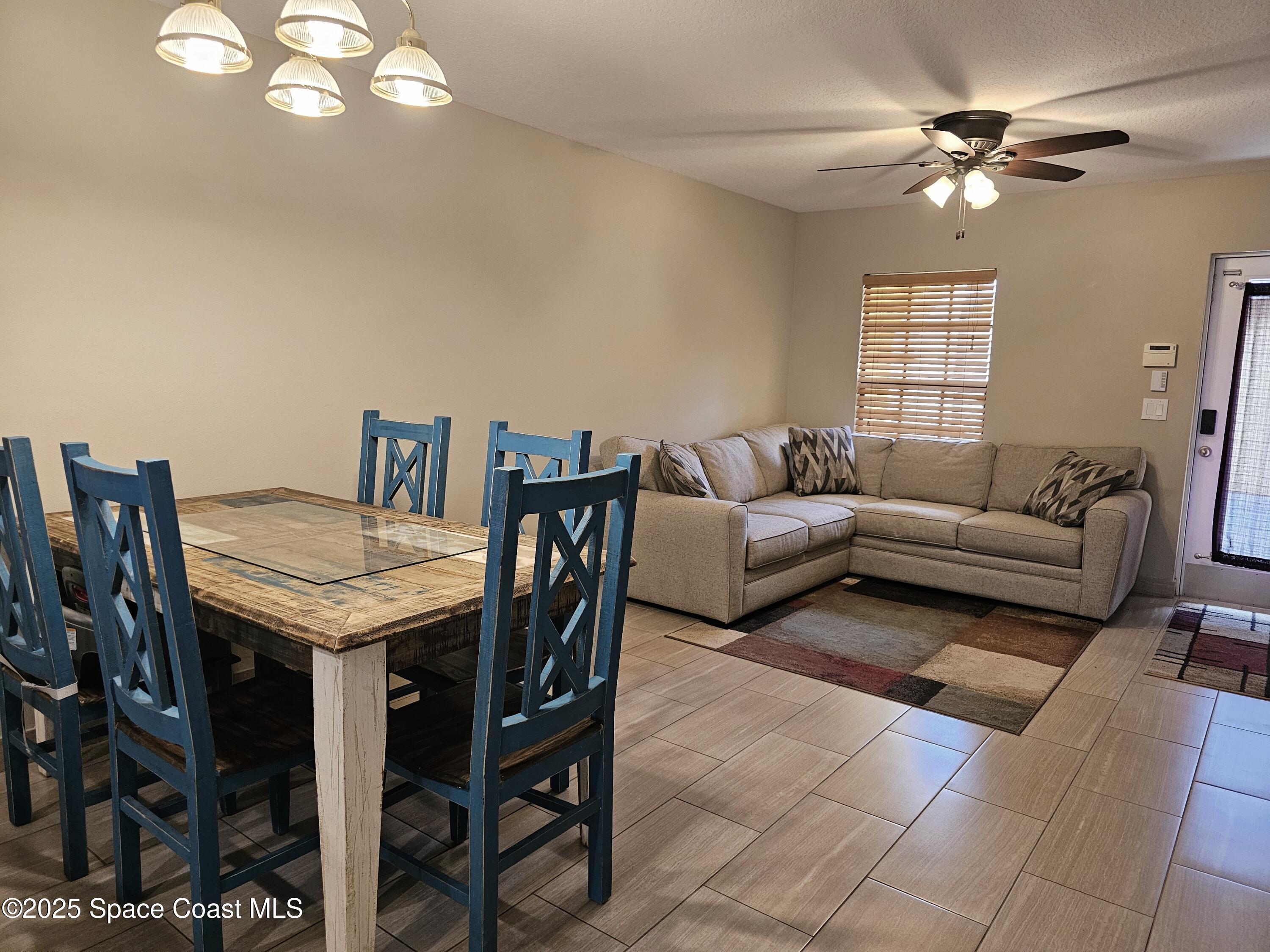 4570 Radiant Way, Unit 104 Melbourne, FL 32901 - Photo 5 of 41 a living room with furniture a chandelier and a window