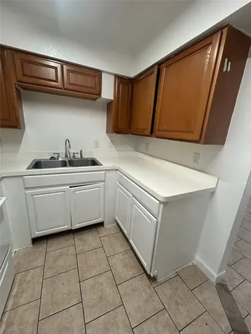 a kitchen with a stove sink and cabinets