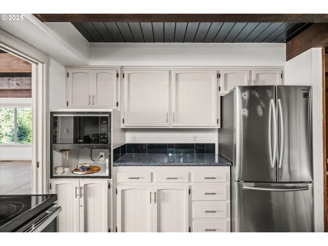 a kitchen with stainless steel appliances granite countertop a sink a refrigerator and a wooden cabinets