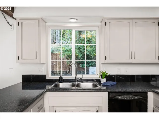 a kitchen with stainless steel appliances kitchen island a refrigerator sink and cabinets