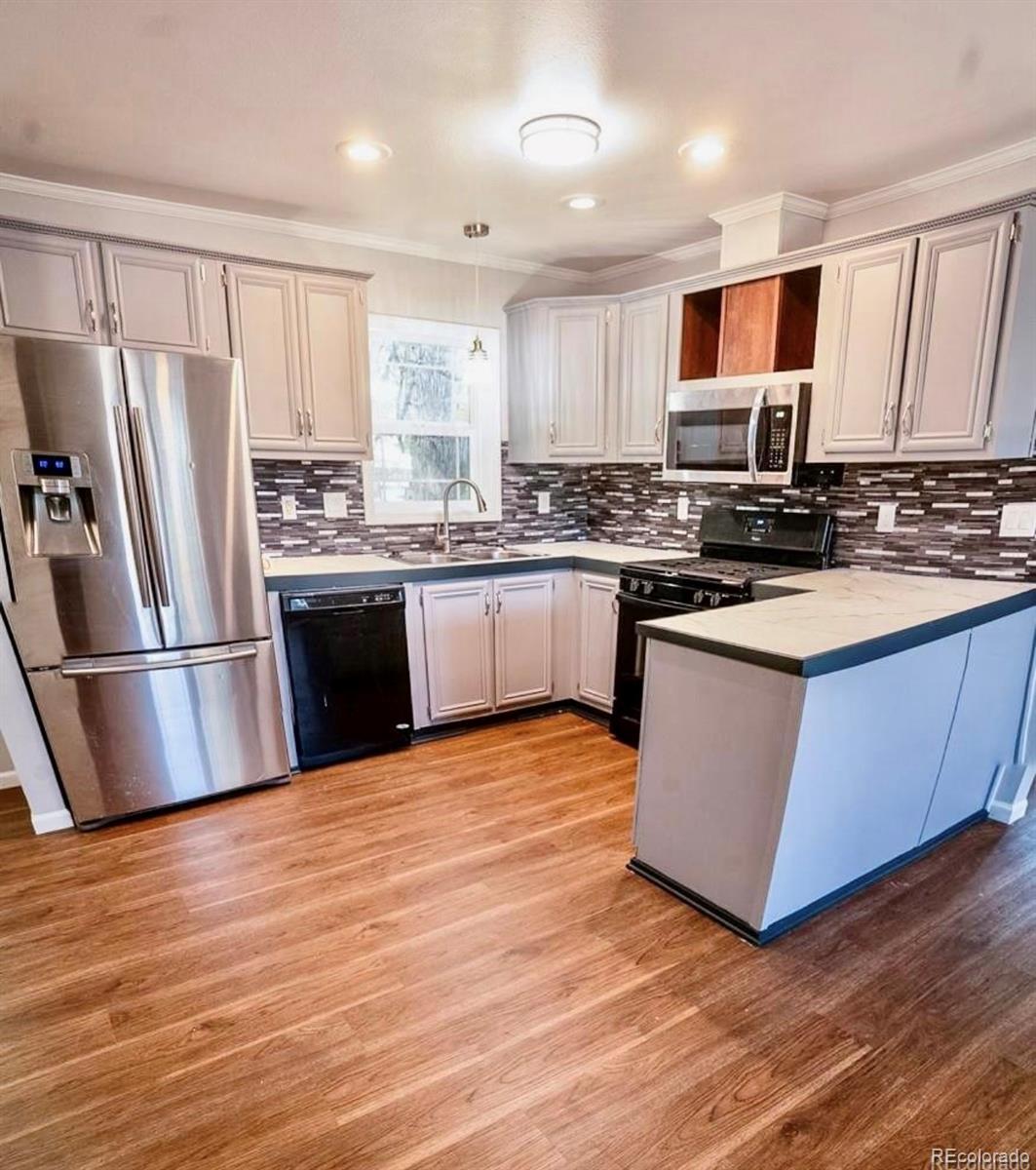 a kitchen with stainless steel appliances granite countertop a stove top oven a refrigerator and a sink