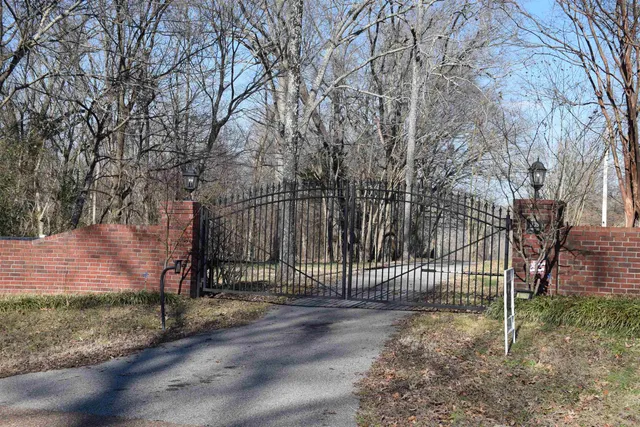 a view of a house with a fence and a tree