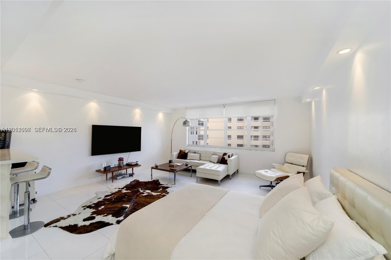 100 Lincoln Road, Unit 605 Miami Beach, FL 33139 - Photo 2 of 17 a living room with furniture and a flat screen tv