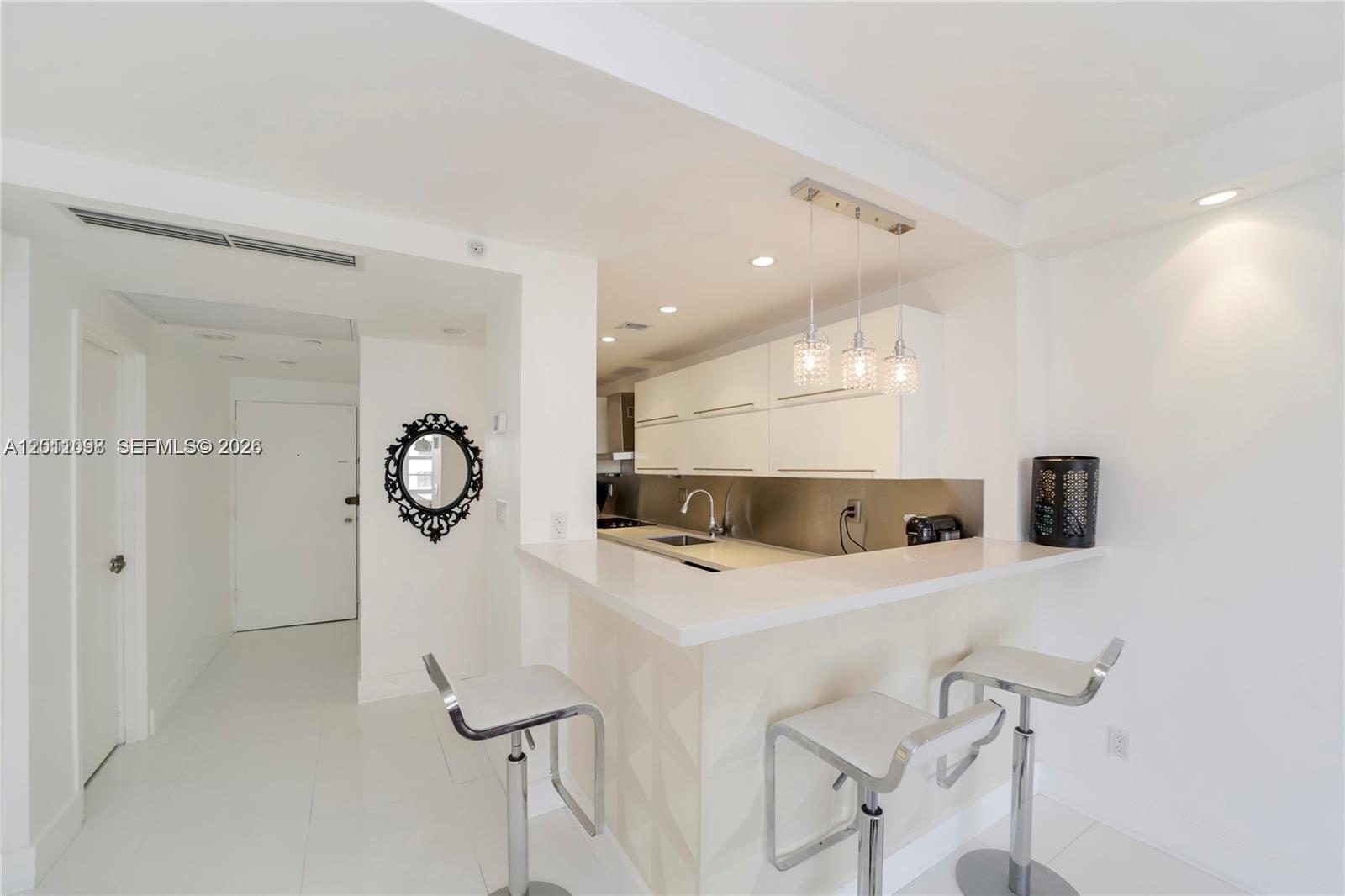100 Lincoln Road, Unit 605 Miami Beach, FL 33139 - Photo 8 of 17 a kitchen with a refrigerator a sink and cabinets
