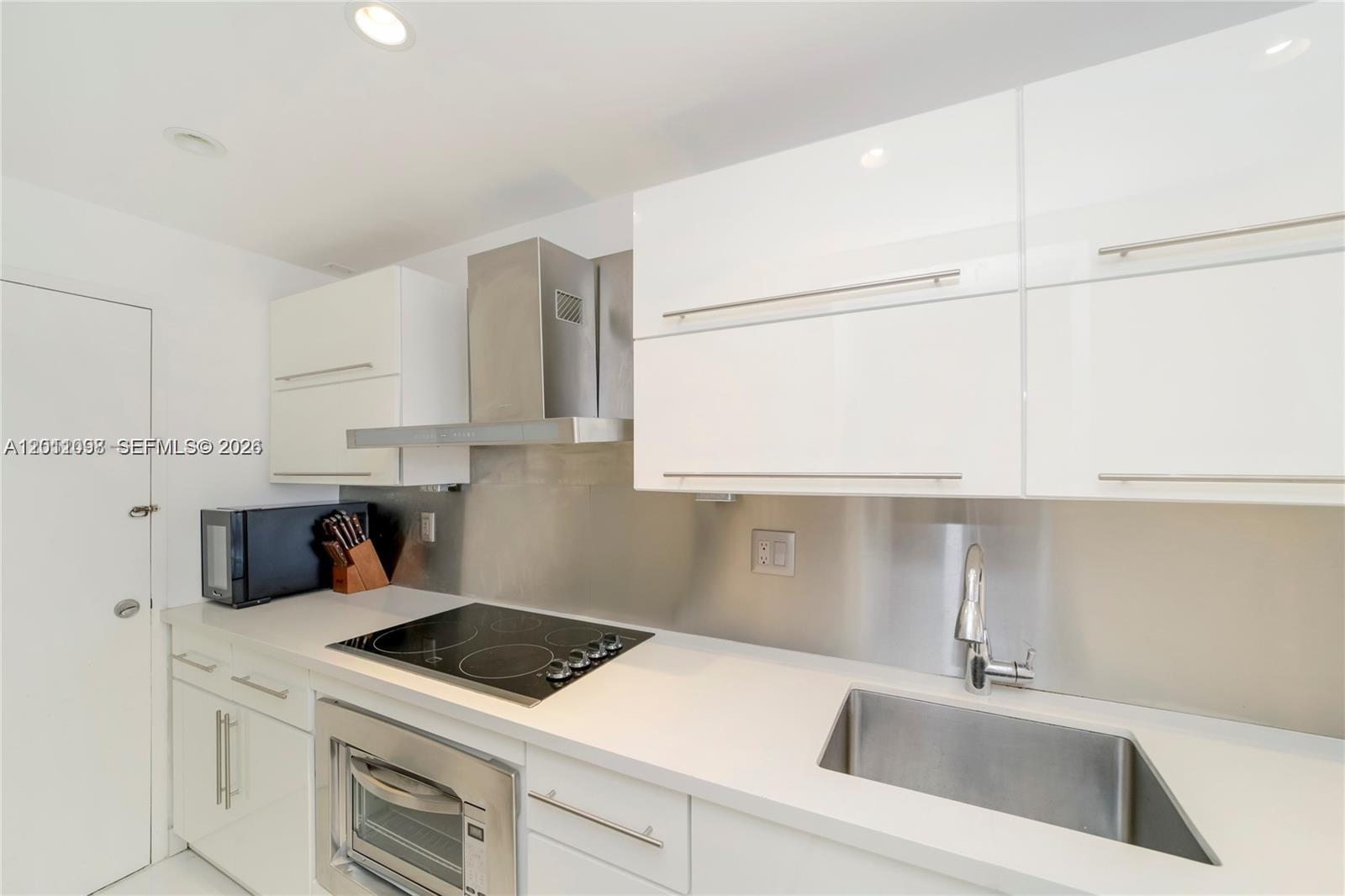 100 Lincoln Road, Unit 605 Miami Beach, FL 33139 - Photo 9 of 17 a kitchen with a sink a stove and cabinets