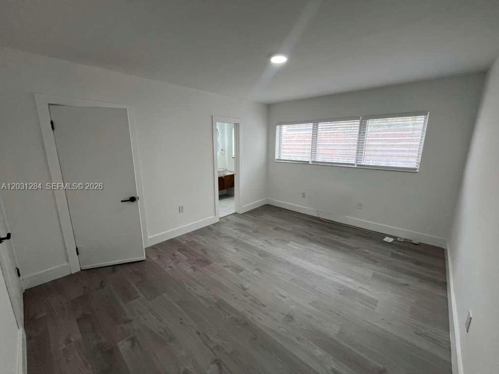 316 Surfside Boulevard, Unit 2 Surfside, FL 33154 - Photo 11 of 13 an empty room with wooden floor and windows