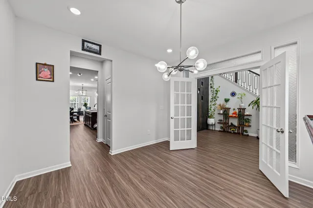 a large kitchen with kitchen island a stove a sink a oven and a dining table with wooden floor