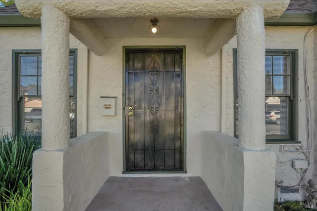 a view of a hallway with wooden floor and a bathroom