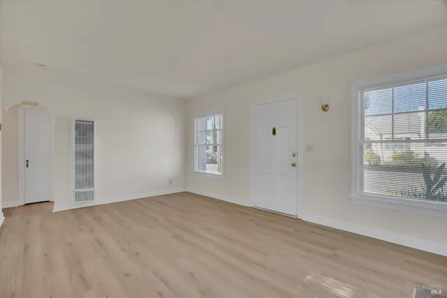 an empty room with windows and closet