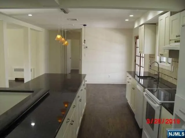 a kitchen with stainless steel appliances granite countertop a sink and a refrigerator