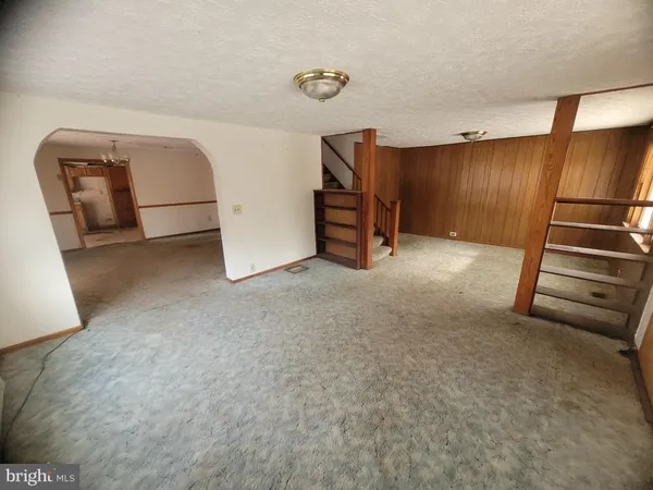 a view of an empty room with stairs and a couch