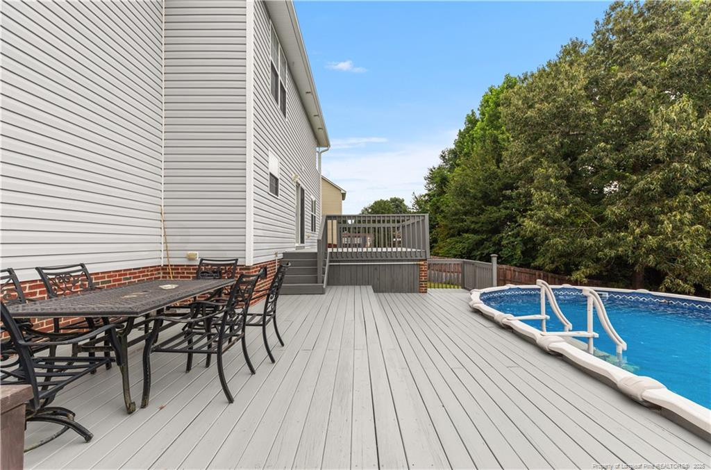 121 Jubilee Court Cameron, NC 28326 - Photo 28 of 36 a view of a roof deck with table and chairs with wooden floor and fence