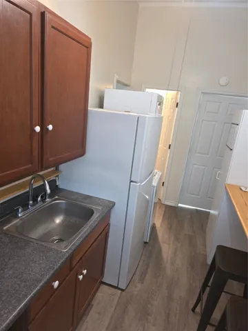a kitchen with a sink a refrigerator and cabinets