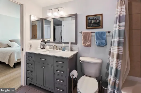 a bathroom with a toilet sink vanity granite and mirror
