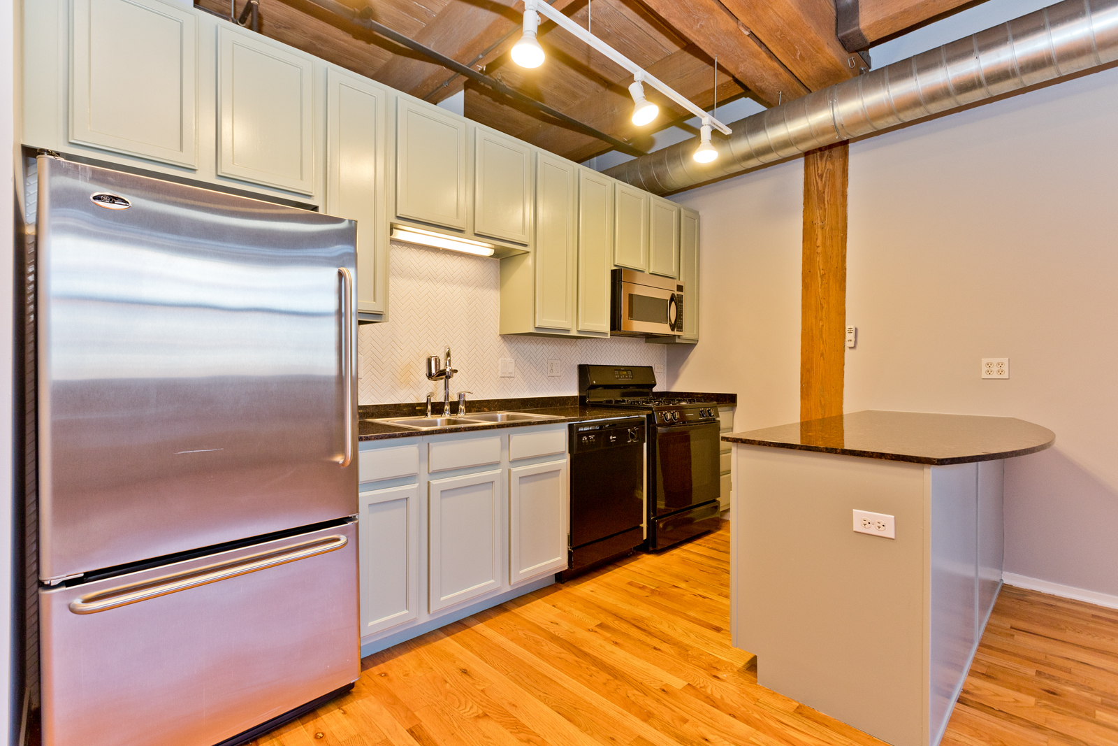 1500 West Monroe Street, Unit 515 Chicago, IL 60607 - Photo 2 of 10 a kitchen with stainless steel appliances granite countertop a refrigerator a stove and a sink